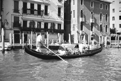 Boats in canal along buildings