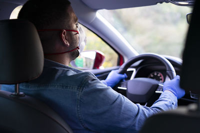 Delivery man driving with face mask in his car. covid-19.