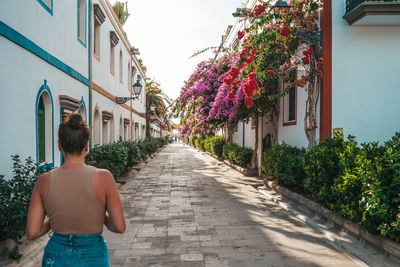 Rear view of woman walking on street in city