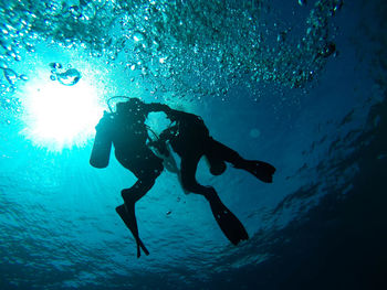 Low angle view of people swimming in sea