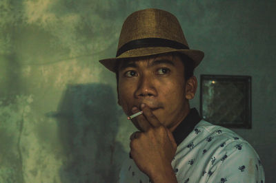 Close-up of man smoking cigarette at home