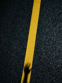 High angle view of yellow arrow symbol on road