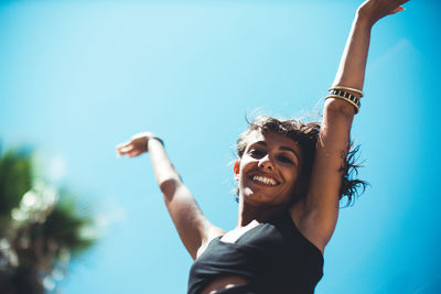 Low angle view of woman against blue sky