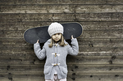 Portrait of boy wearing hat standing against wall