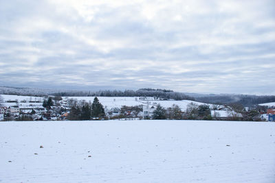 Scenic view of snowcapped city against sky during winter