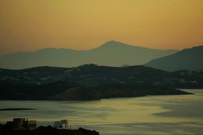 Scenic view of sea against mountains during sunset