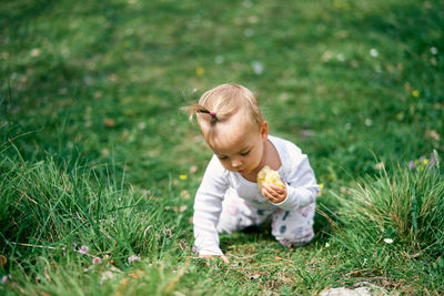 Full length of cute girl playing on grass outdoors