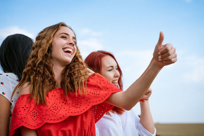 Cheerful girls dancing on the background of the sky