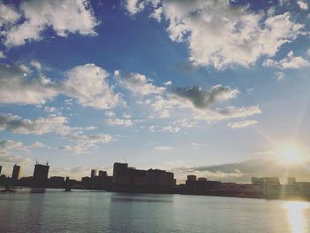 Scenic view of river by buildings against sky