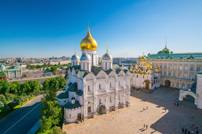 Buildings in city against clear blue sky