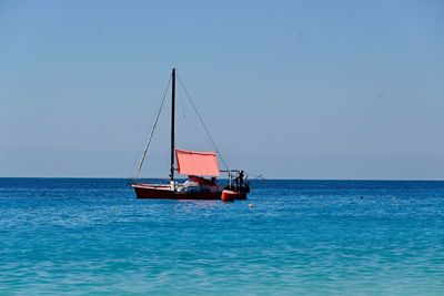 Sailboat sailing on sea against clear sky