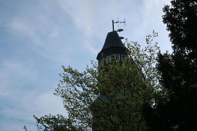 Low angle view of trees and building against sky