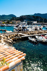 Boats moored at harbor against clear sky