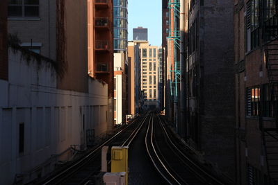 Railroad tracks in city against sky