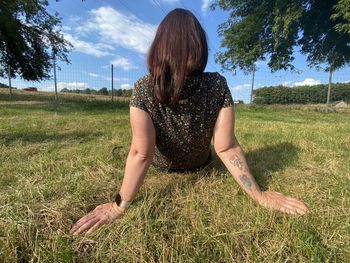 Rear view of woman on field against sky