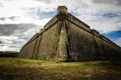 Low angle view of old building against cloudy sky