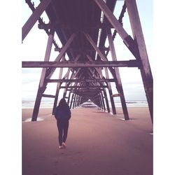 Rear view of woman walking on beach