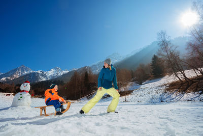 Rear view of woman standing on snow covered mountain