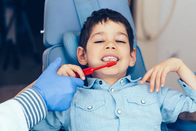 Cropped image of dentist examining boy at clinic