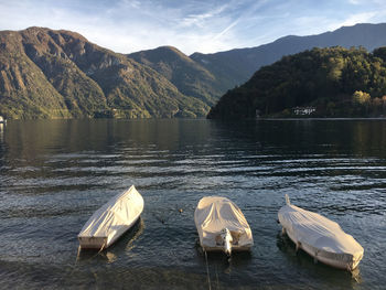 Boats in lake against mountains