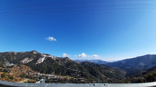 Scenic view of snowcapped mountains against blue sky