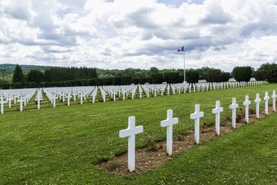 Scenic view of cemetery against cloudy sky