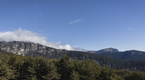 Scenic view of mountains against blue sky