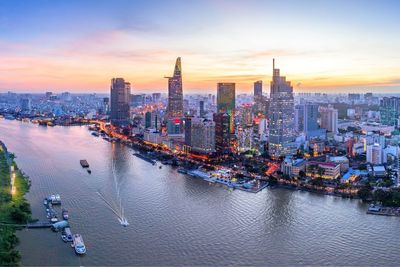 Aerial view of city at waterfront during sunset