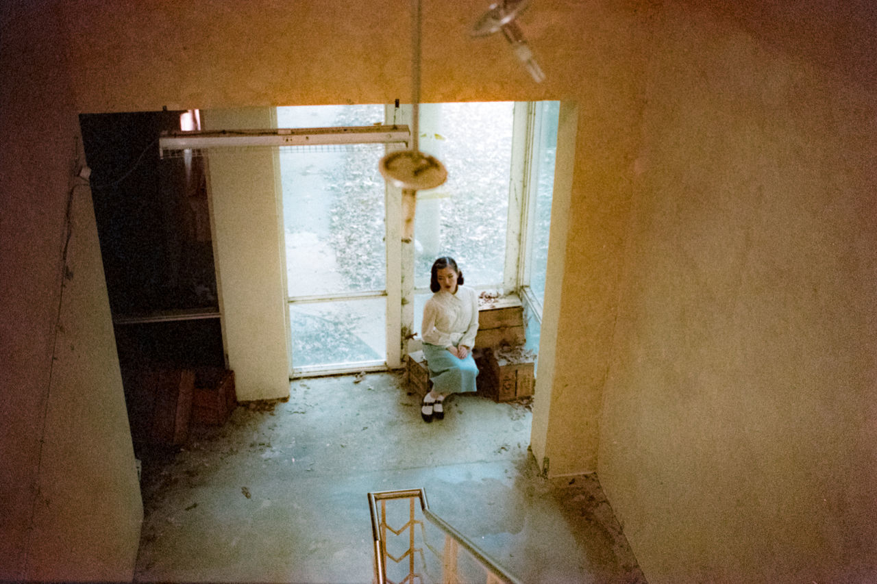 indoors, architecture, one person, staircase, entrance, door, full length, adult, home interior, casual clothing, standing, flooring, domestic room, abandoned, real people, building, women, lifestyles, built structure, teenager