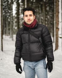 Portrait of young man standing in snow