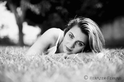 Portrait of young woman lying on grass