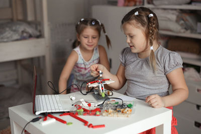 Portrait of siblings playing with toy blocks at home