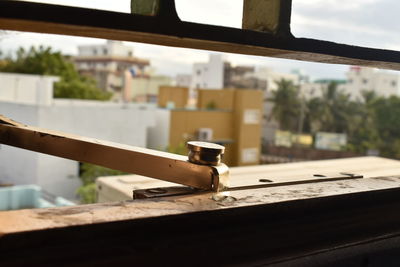 Close-up of rusty metal on table against window