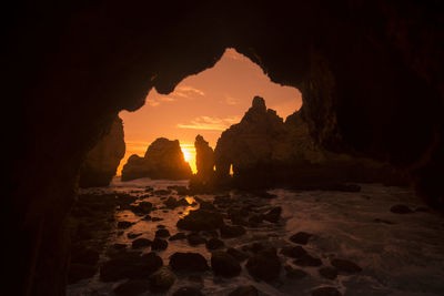 Rock formation in cave against sky