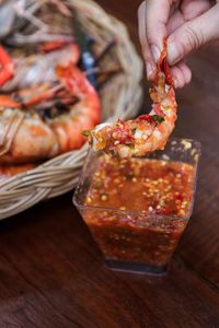 Close-up of hand holding ice cream on table