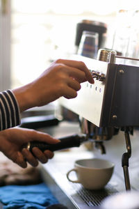 Midsection of man holding coffee cup