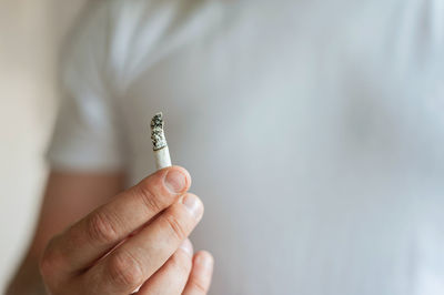 Close-up of hand holding cigarette