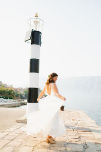 Woman with umbrella standing against the sky