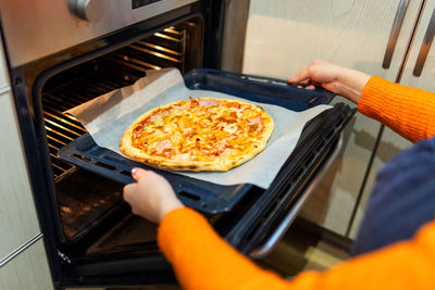 Cropped hand of person preparing food in kitchen