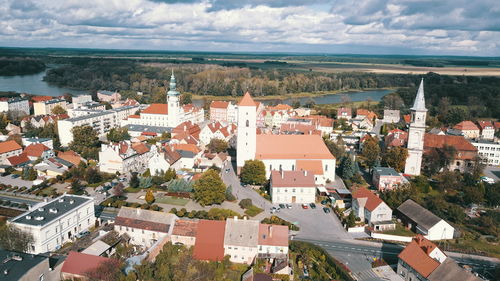 Aerial view of town by sea against sky