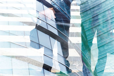 Low section of man walking on modern office building