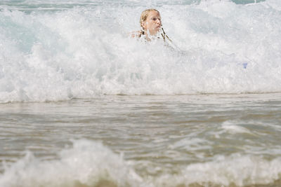 Woman surfing at sea