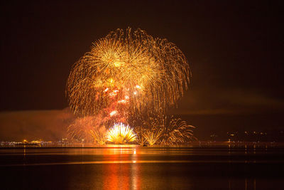 Firework display over river at night