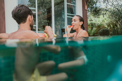 Portrait of woman sitting by swimming pool