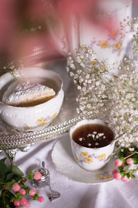 White still life with cheesecake and gypsophila and cup of tea, light and airy