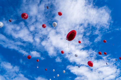 Many released flying balloons with card in blue sky - wedding balloons