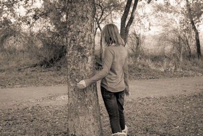 Rear view of woman standing in forest