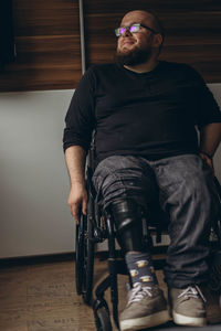 Low angle view of young man standing against wall