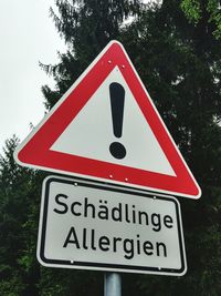 Low angle view of road sign against trees