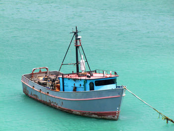 Old and rusty fishing boat anchored in the caribbeans